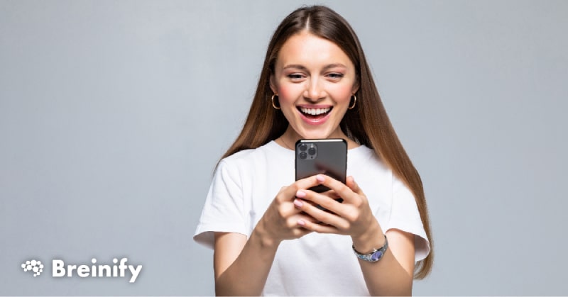 Young woman smiling and using iPhone.
