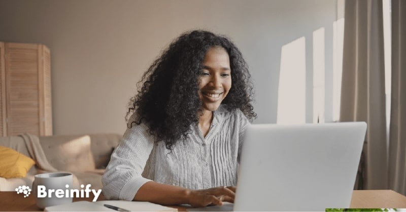 African American woman using computer and smiling.