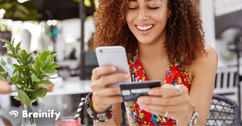 Woman smiling and using phone to shop online.
