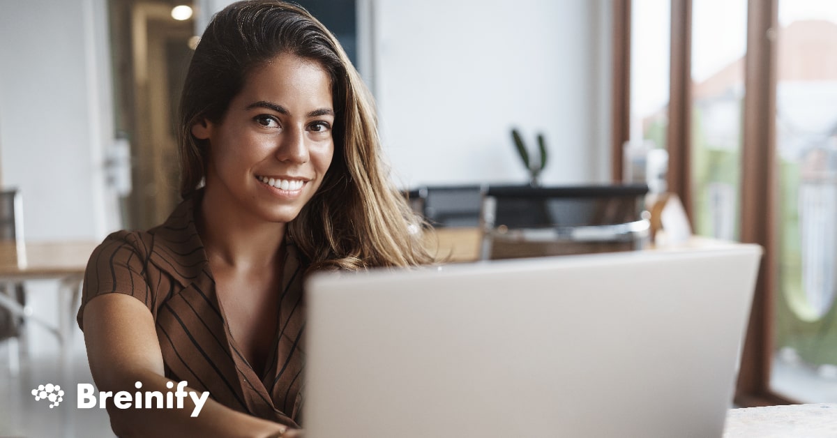 Woman smiling in front of a laptop